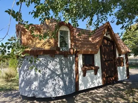 White cottage with dark sculpted timber and curved roofline